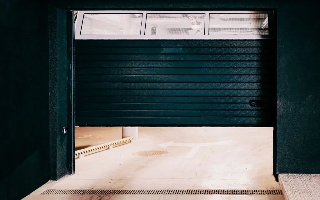Modern garage door open at dusk, viewed from inside the garage — the kind of clean, working door Tyson Garage Door installs across DFW