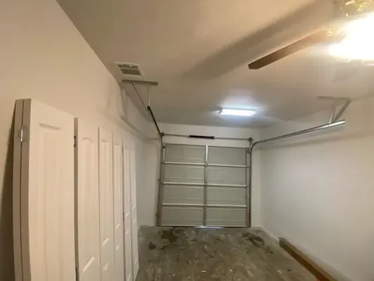 Garage door track and spring hardware exposed during a repair visit